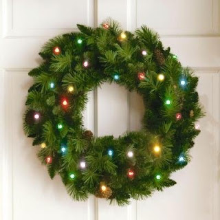 Christmas_wreath_decoration_with_Xmas_lights_on_wall_photo.jpg