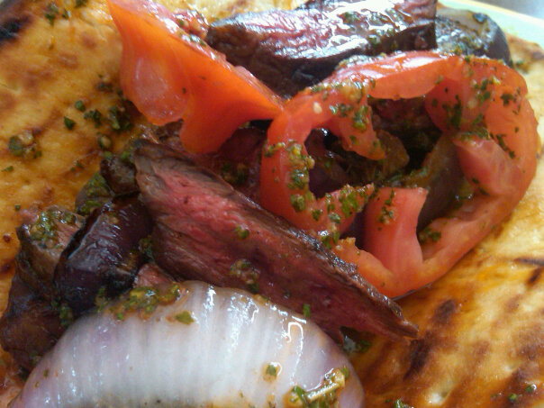 grilled-gaucho-steak-with-grilled-red-onions-and-heirloom-tomatoes-on-a-pita.jpg