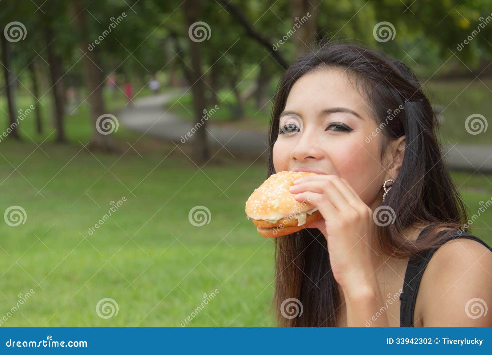 girl-eating-cheeseburger-teenage-park-33942302.jpg