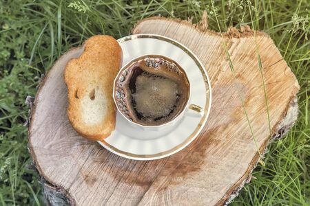 62539599-in-the-garden-on-the-stump-of-a-sawn-tree-trunk-is-a-black-cup-of-coffee-next-on-the-plate-are-toast.jpg