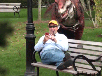raptor-scares-guy-on-bench-prank-dinosaur-14060619444.gif